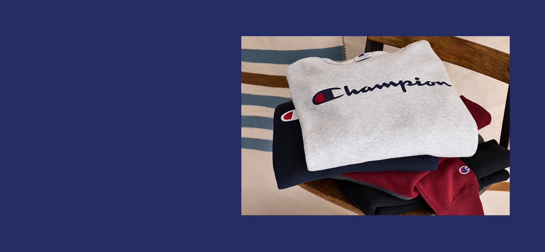 Stack of Champion branded sweatshirts on a wooden surface