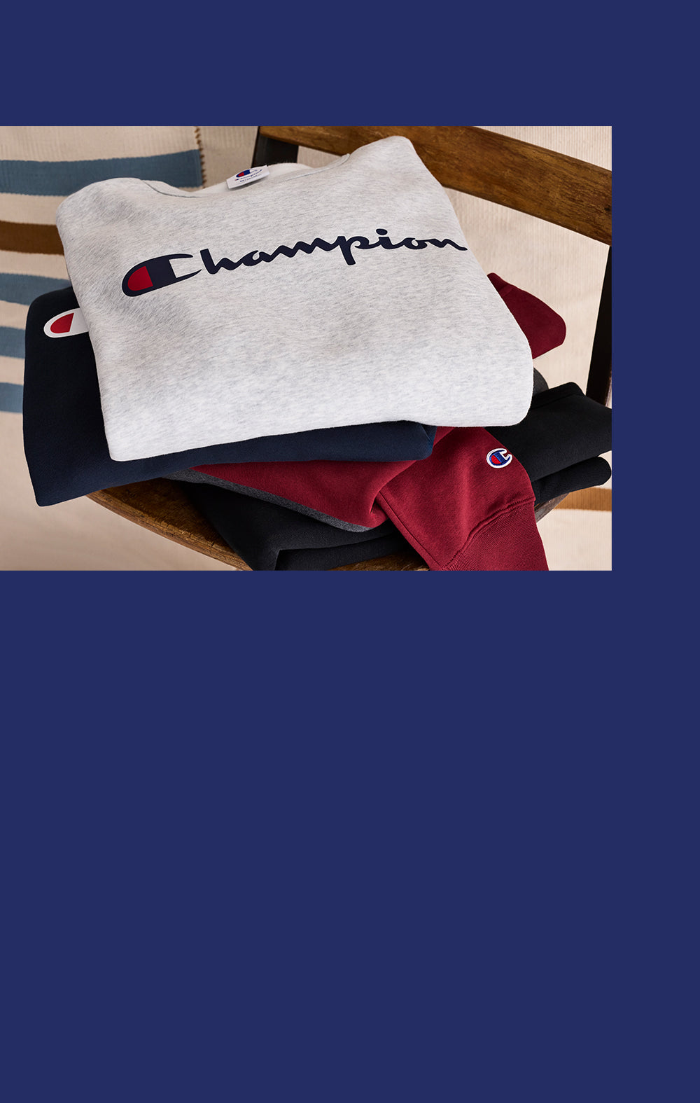 Stack of Champion branded sweatshirts on a wooden surface