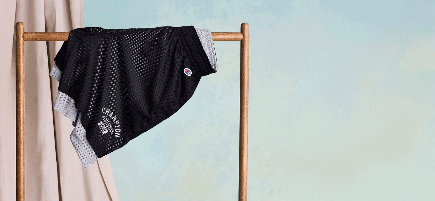 Animated GIF of multiple pairs of shorts hanging from a clothing rack against a blue background.