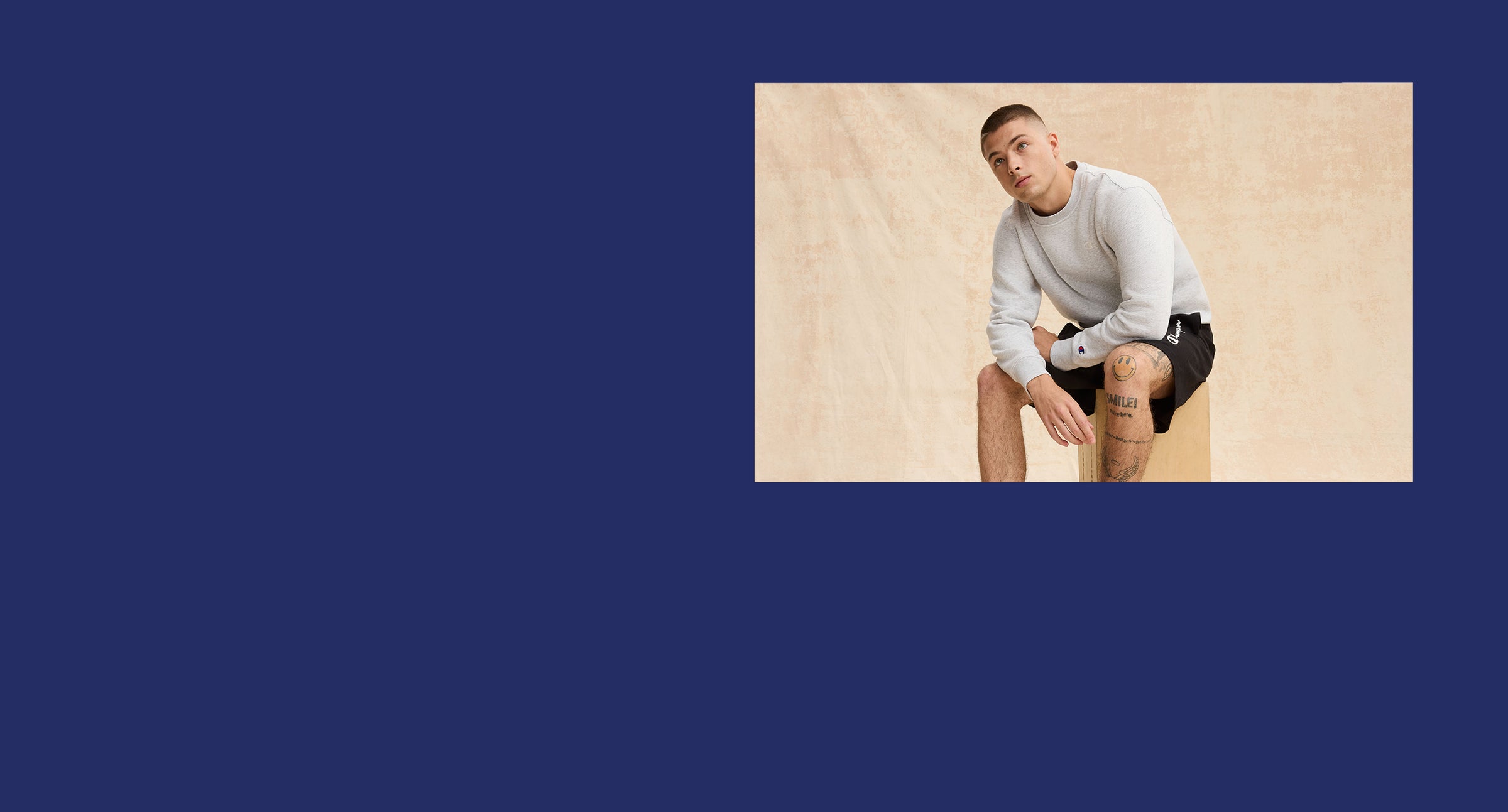 Man sitting on a beige surface with a blue background