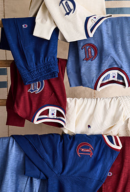 Collection of sports team apparel with logos on a striped background