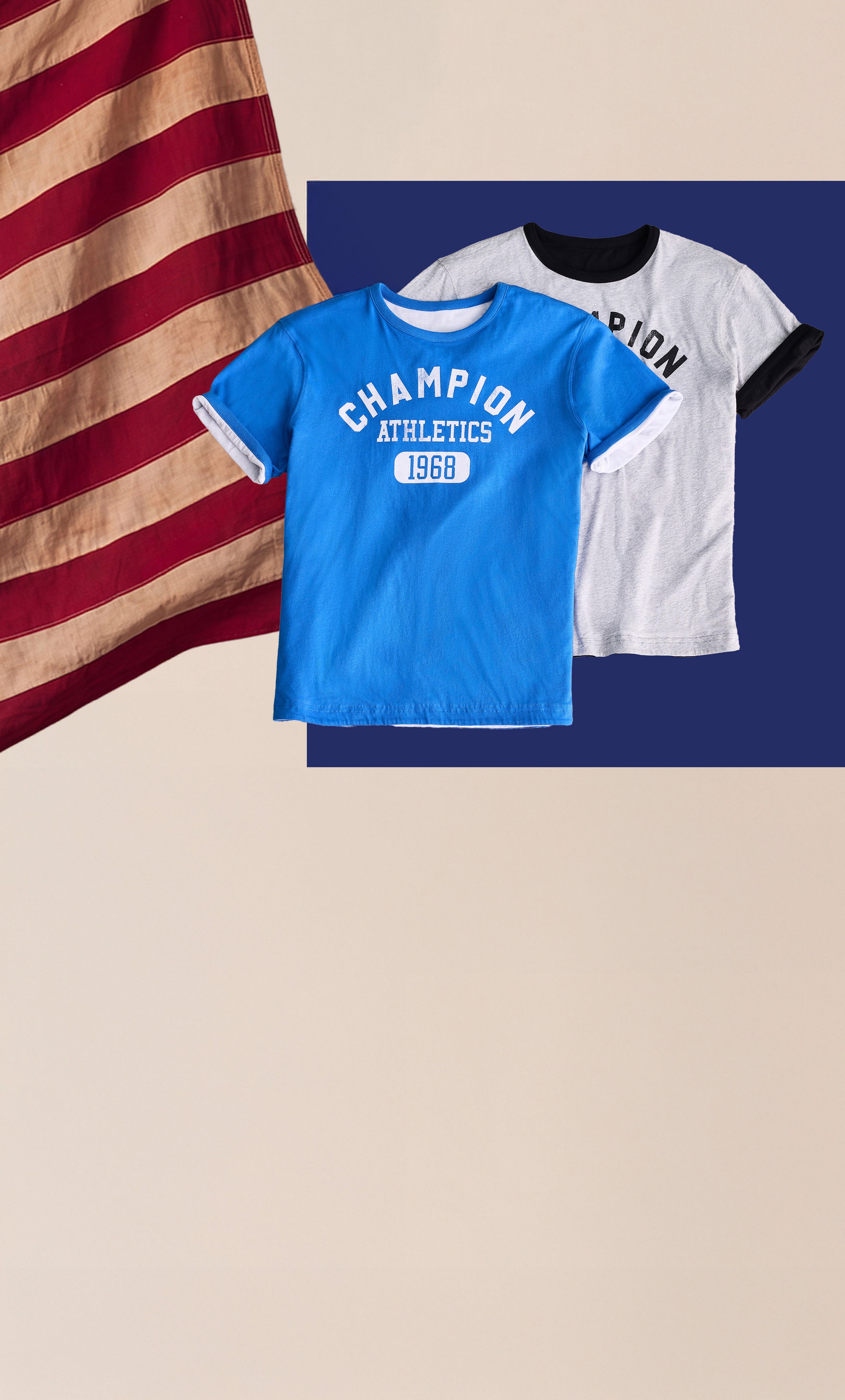 Two Champion athletic t-shirts displayed against a dark blue rectangular backdrop on a beige background, with a distressed American flag graphic on the left. One shirt is bright blue with white lettering reading 'CHAMPION ATHLETICS 1969,' and the other is white with black ringer-style trim and black lettering.