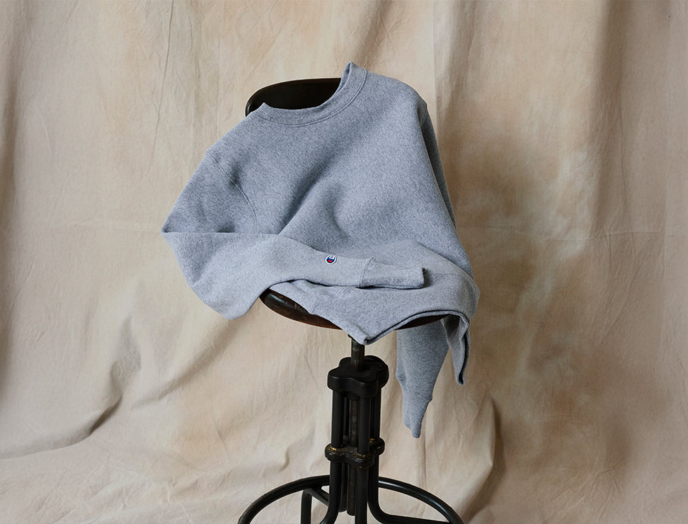 Gray sweatshirt on a chair against a beige curtain background