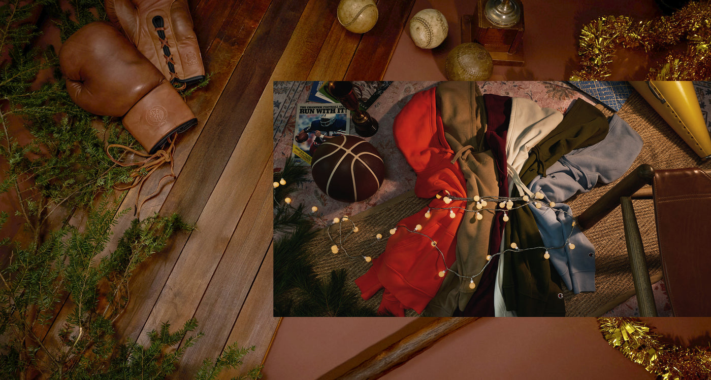 Close-up of a person wearing a coat with a red interior, surrounded by various items on a wooden surface.