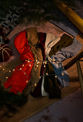 Colorful fabric swatches arranged on a textured surface with string lights.