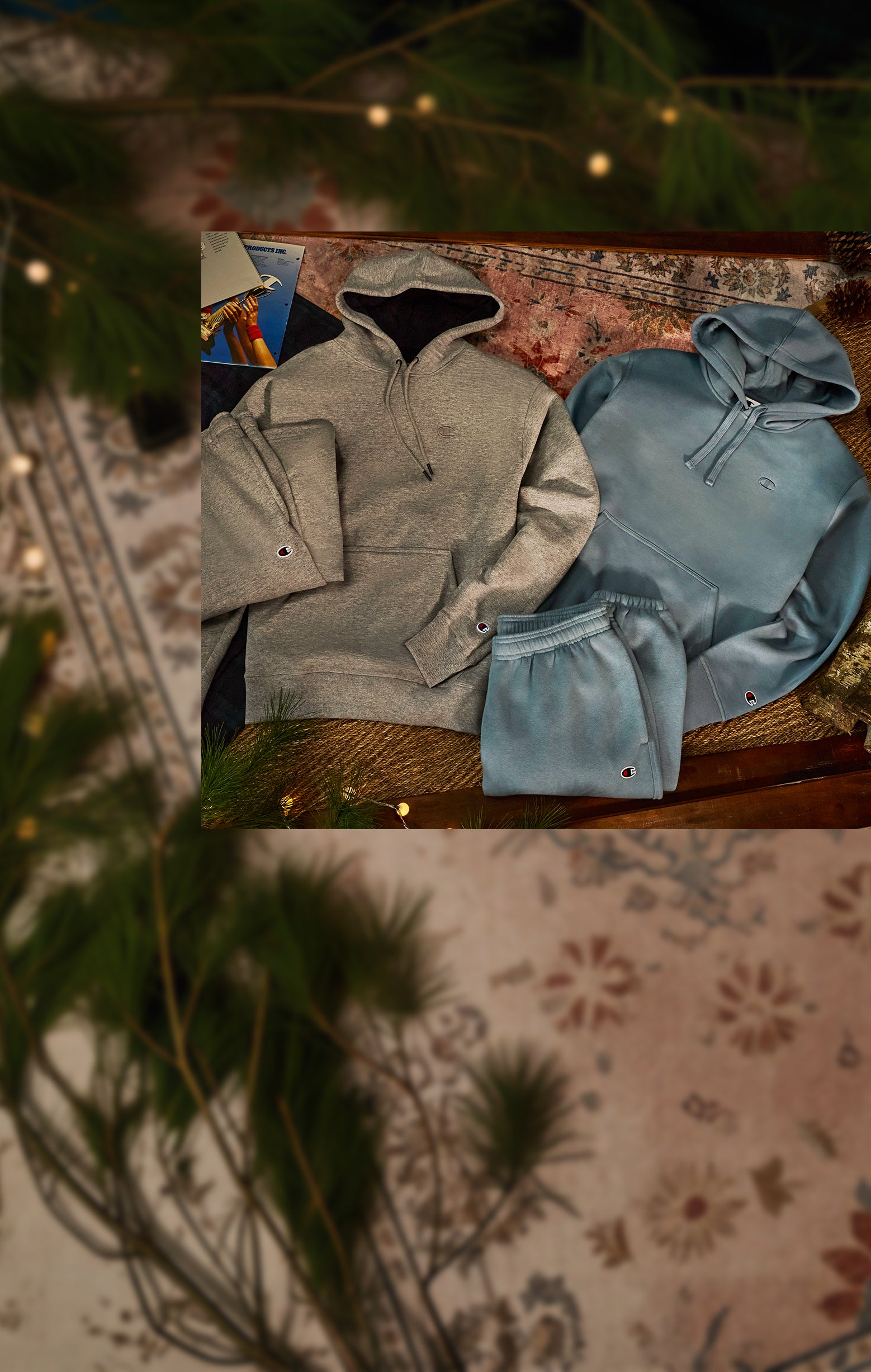 Two hoodies, one gray and one blue, on a wooden surface with a blurred background.