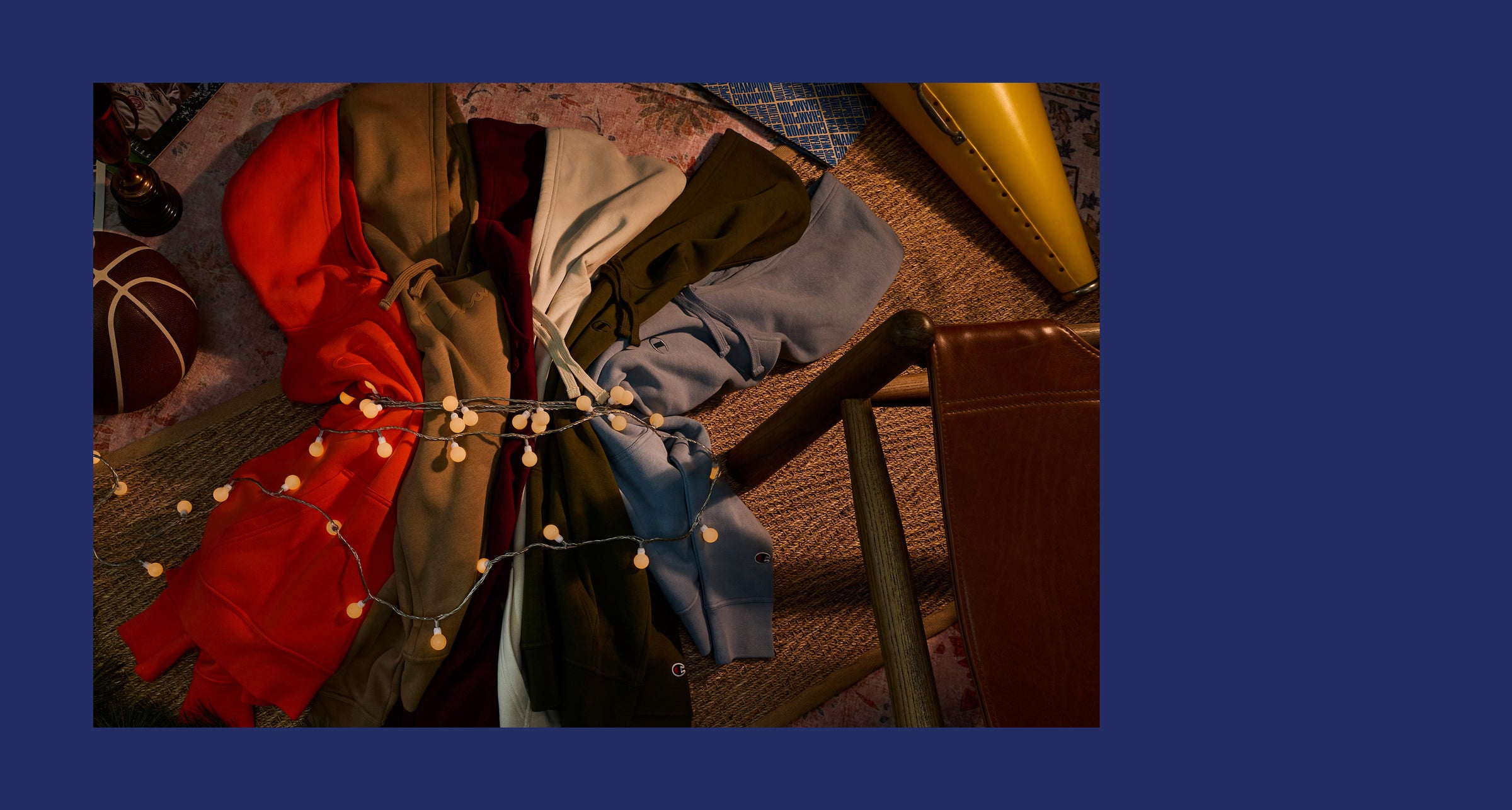 Colorful scarves draped over a chair with string lights, on a wooden floor.