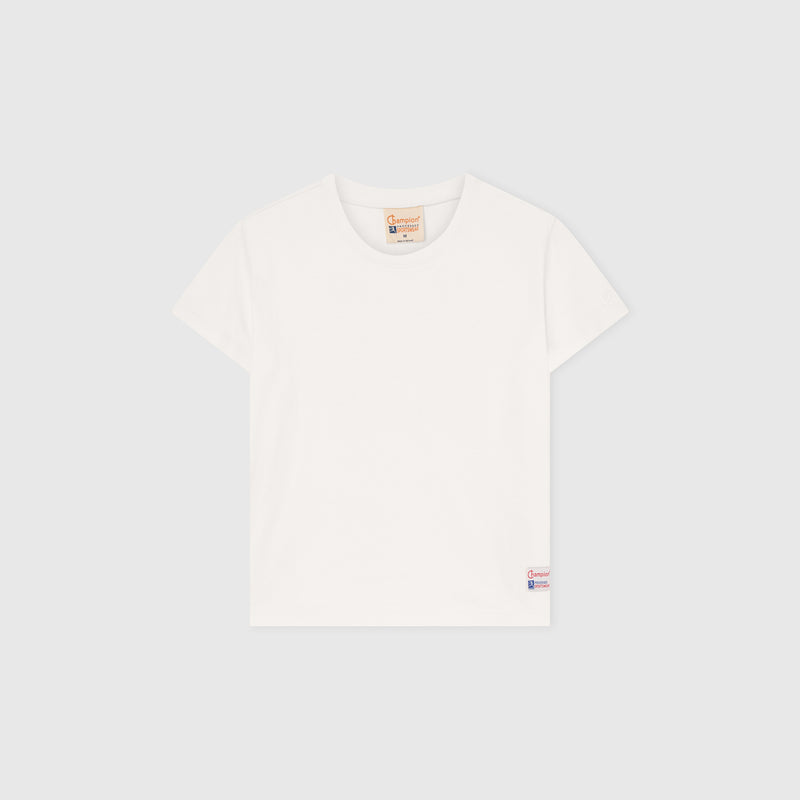 A Women’s Knitted Crewneck T-Shirt by Champion is laid flat on a light gray background, showcasing a relaxed fit with a small Champion logo tag near the bottom hem and a brown label at the neckline. Inspired by Champion’s Reverse Weave heritage, this classic white tee offers everyday comfort and timeless style.