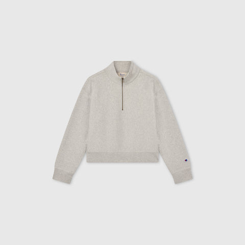 Light gray Women’s Knitted Half Zip Sweatshirt by Champion, featuring long sleeves, a cropped half-zip collar, and ribbed cuffs and hem, displayed on a plain white background—a modern essential in women’s sportswear.