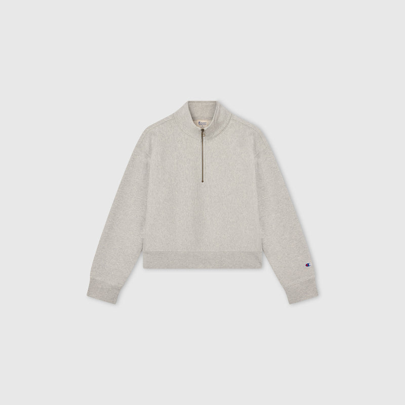 Light gray Women’s Knitted Half Zip Sweatshirt by Champion, featuring long sleeves, a cropped half-zip collar, and ribbed cuffs and hem, displayed on a plain white background—a modern essential in women’s sportswear.