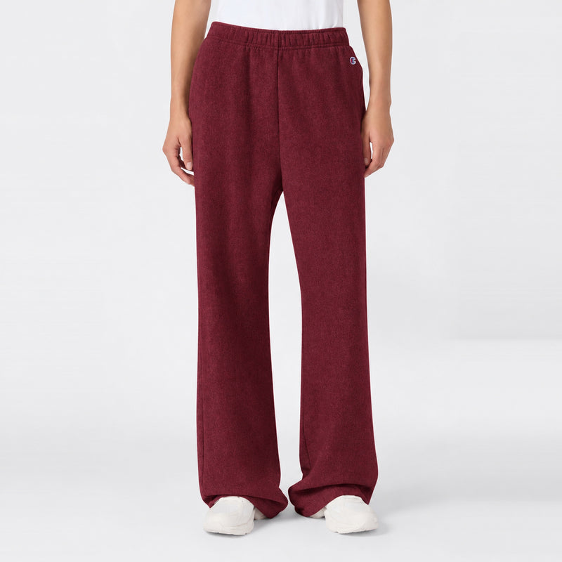 Maroon high-waisted Women’s Knitted Flare Pants by Champion with an elastic waistband and white sneakers.