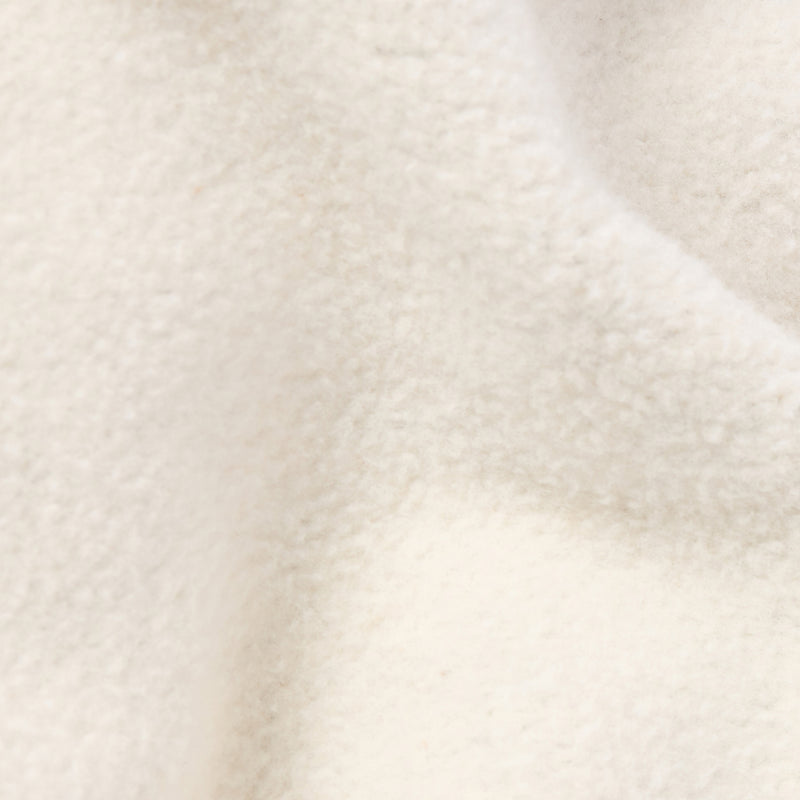 Close-up of a soft, off-white heavyweight fleece fabric with gentle folds and a slightly fuzzy appearance, showcasing the quality of Champion Women’s Knitted Flare Pants.