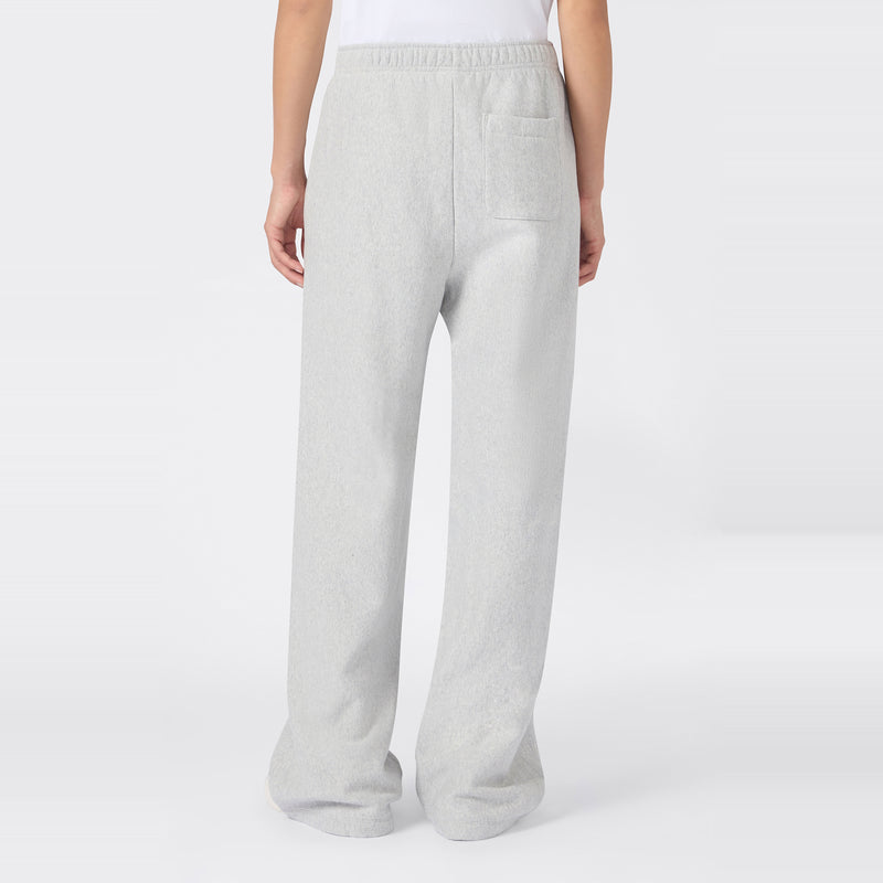 A person wearing Champion Women’s Knitted Flare Pants in light gray, featuring a heavyweight fleece construction, elastic waistband, and a single back pocket—an effortless update on classic women’s flared sportswear, shown from the back against a plain white background.