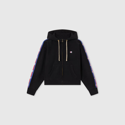 Women’s Icon Hooded Full Zip Sweatshirt by Champion features front pockets, hood drawstrings, and blue-and-red logo stripes on both sleeves. Made from heavyweight fleece and shown on a plain gray background.