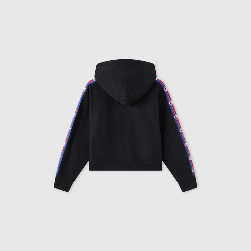The Women’s Icon Hooded Full Zip Sweatshirt by Champion is shown from the back in black, featuring red, white, and blue patterned stripes running down both sleeves. Made from heavyweight fleece, this hoodie stands out against a plain light gray background.