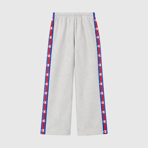 Light gray Champion Women’s Knitted Wide Leg Pants featuring a vertical stripe down each leg with a repeating logo pattern in red, white, and blue.