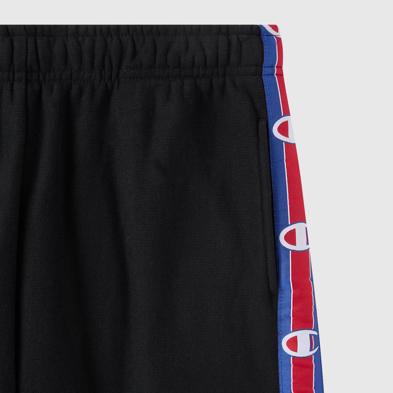 Black Women’s Knitted Wide Leg Pants by Champion, featuring an elastic waistband and red and blue side stripes adorned with repeating white C logos. The upper half of these Champion pants is visible, showcasing their iconic sporty style.