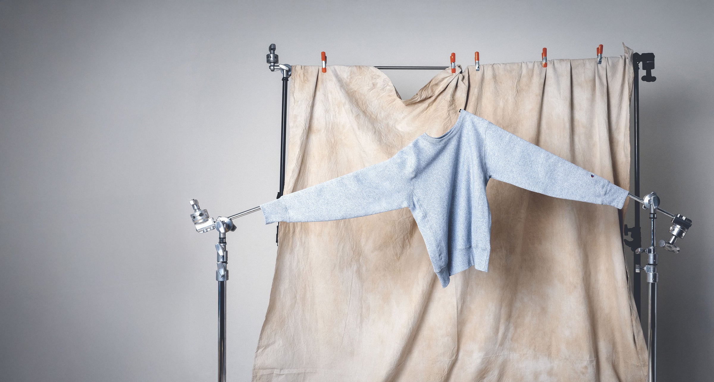 Light blue sweater on a hanger against a neutral backdrop