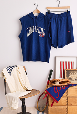Navy blue 'Champion' sleeveless hoodie and shorts set on a hanger against a white wall.