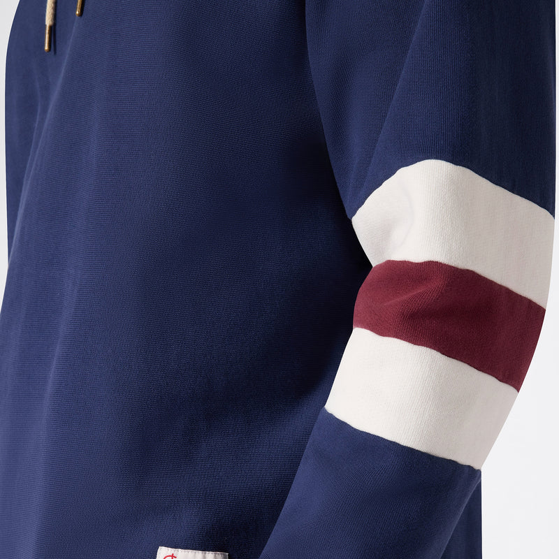 A close-up of the sleeve of the Men’s Knitted Hooded Sweatshirt by Champion in navy blue, featuring a white and maroon horizontal stripe near the elbow and crafted from heavyweight fleece for lasting comfort.