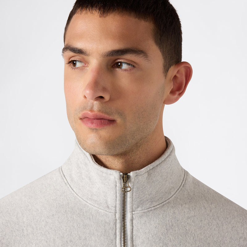 A young man with short dark hair wears a light gray Champion Men’s Knitted Half Zip Sweatshirt and looks to his left against a plain white background.