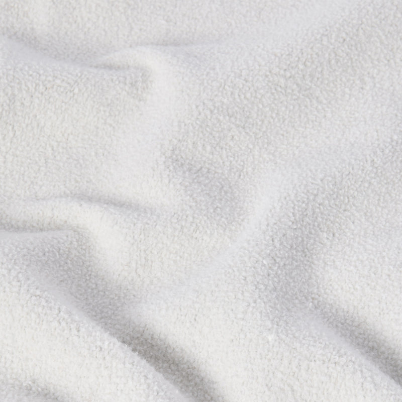 A close-up of a soft, white, textured fabric with gentle folds and shadows evokes a cozy, plush feel—similar to the signature Reverse Weave technique found in the Champion Men’s Knitted Crewneck Sweatshirt (Reversible + Vintage Wash).