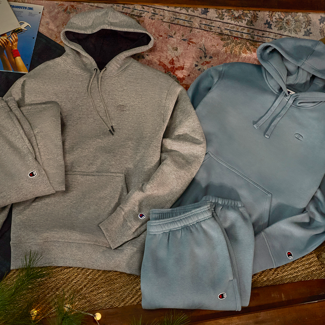 Gray and blue hoodies with matching pants on a textured surface