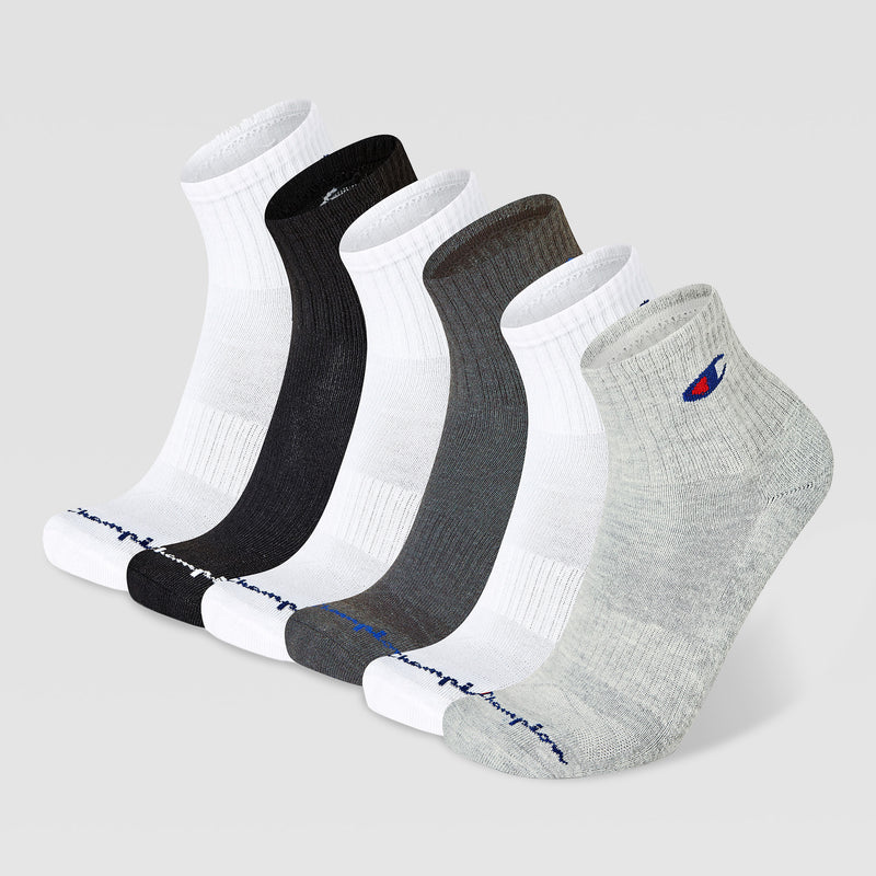 Six Champion Men’s Cushion High Quarter socks in white, black, dark gray, and light gray stand upright on a plain light gray background. Each features Champion branding near the toe and logo on the ankle.