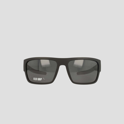 A pair of Champion Men's Polarized Grilamid Flex Grip Tip - Large sunglasses, featuring a black rectangular frame with dark lenses, is displayed against a light gray background. The left lens displays the white "FLEX GRIP" text. Designed for ultra-lightweight comfort, these sunglasses also offer an RX-able frame for added versatility.