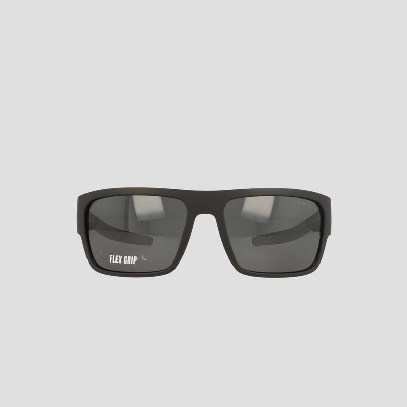 A pair of Champion Men's Polarized Grilamid Flex Grip Tip - Large sunglasses, featuring a black rectangular frame with dark lenses, is displayed against a light gray background. The left lens displays the white "FLEX GRIP" text. Designed for ultra-lightweight comfort, these sunglasses also offer an RX-able frame for added versatility.