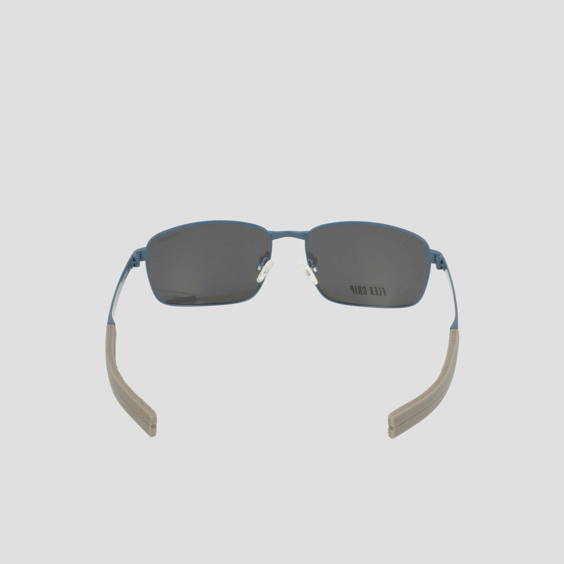 Men's Polarized Stainless ST-Shirtl Flex Grip Tip sunglasses by Champion, featuring rectangular, dark polarized lenses, blue metal frames, and beige textured temple arms with flexible grip tips. Designed for active lifestyles, these retainer frame sunglasses display subtle Champion branding on the right lens and are shown from the front.