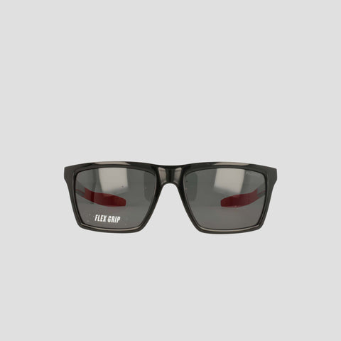 Black sunglasses with rectangular, polarized lenses and a slight reflection, featuring the text FLEX GRIP on the left lens. The lightweight, RX-able TR90 Grilamid frame from Champion's Men's Polarized Grilamid Flex Grip Tip - Medium is positioned against a plain light gray background.