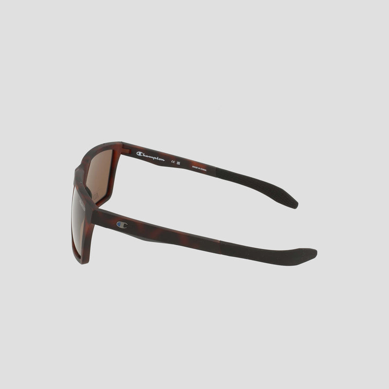 Men's Polarized Grilamid Flex Grip Tip - Medium sunglasses by Champion, featuring a brown tortoiseshell frame with black arms, are shown from an angle that highlights the side and inner details. Crafted from lightweight Grilamid for comfort and durability, these RX-able frames have the Champion logo visible on both the inner arm and temple. Set against a plain light gray background.