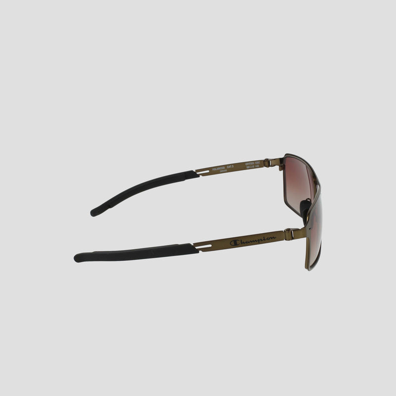 Side profile of the Men's Polarized Stainless ST-Shirtl Comfort Fit sunglasses by Champion, featuring a gold stainless steel frame, brown-tinted polarized lenses, black temple tips, and an engraved Champion logo on the arm. Light gray background.