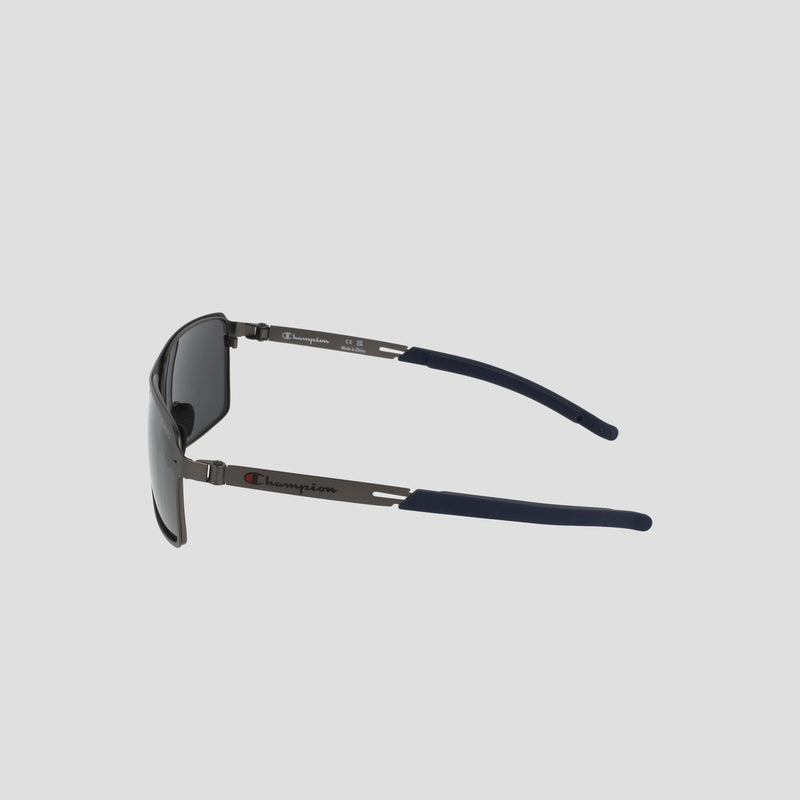 Side view of Champion Men's Polarized Stainless ST-Shirtl Comfort Fit sunglasses, black with metal arms and navy blue adjustable rubber tips, featuring the Champion logo on the left temple, on a light gray background.