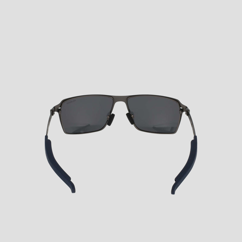 Front view of Champion Men's Polarized ST-Shirtl Comfort Fit sunglasses, featuring black rectangular frames, polarized lenses, blue adjustable rubber tips, and a lightweight stainless steel frame on a light gray background.