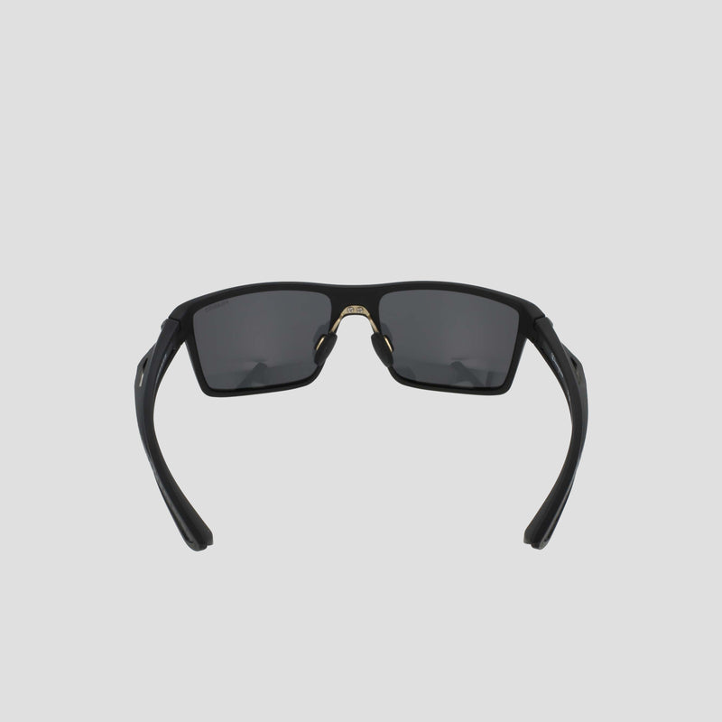 Men's Polarized Comfort Fit - Medium sunglasses by Champion, shown from the front against a light gray background. Featuring a lightweight black rectangular frame with dark lenses, the partially folded arms and visible nose pads highlight their comfortable design.