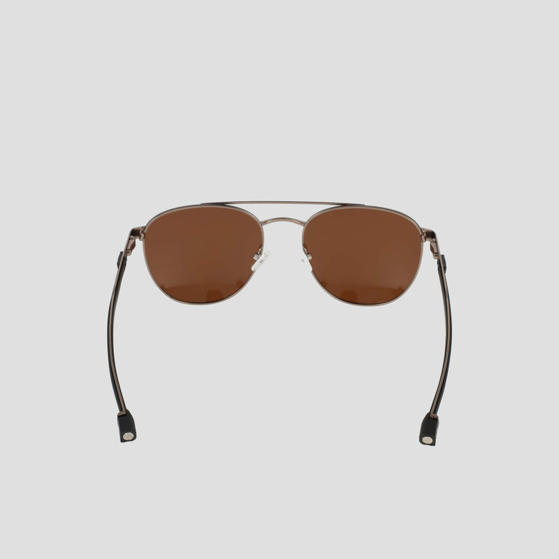 The Champion Men’s Polarized Retainer Stainless ST-Shirtl Aviator sunglasses are shown on a light gray background, featuring brown polarized lenses and a slim, lightweight stainless steel frame with straight arms finished in black plastic tips.