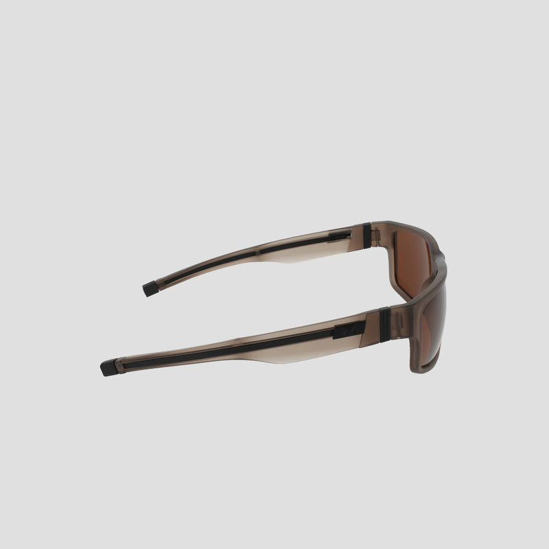 Side view of the Champion Men's Polarized Retainer Rectangle sunglasses, featuring thick, translucent TR90 construction frames in brown with matching brown tinted lenses, displayed against a plain light gray background.