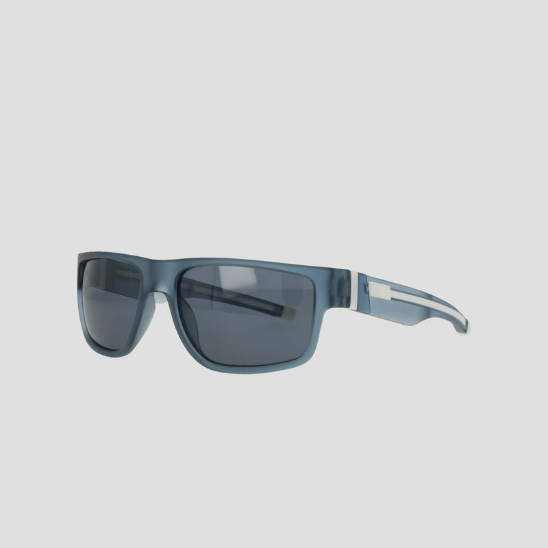 Champion Men’s Polarized Retainer Rectangle sunglasses feature blue, rectangular frames made from thick, glossy TR90 construction. The dark polarized lenses offer superior glare protection, while the slim temples are enhanced by a metallic accent near the hinges for added durability and style. These Champion sunglasses are showcased against a plain light gray background.