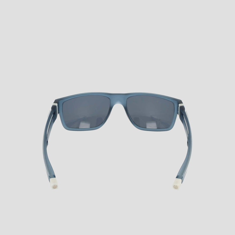 Champion Men's Polarized Retainer Rectangle sunglasses in blue, featuring a rectangular shape with dark polarized lenses. Seen from the back, these high-performance sunglasses highlight their curved arms with white tips and are crafted from durable TR90 material. Displayed against a plain light background.