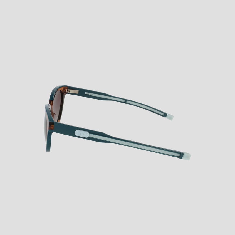 The Champion Women's Polarized Retainer Round sunglasses feature blue frames with white accents and tinted lenses, shown in a side view on a plain white background—a stylish addition to any women’s eyewear collection.