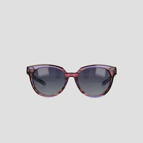 The Champion Women's Polarized Retainer Round sunglasses feature purple translucent round frames and dark tinted lenses, making a bold statement in women’s fashion eyewear, showcased on a plain light gray background.