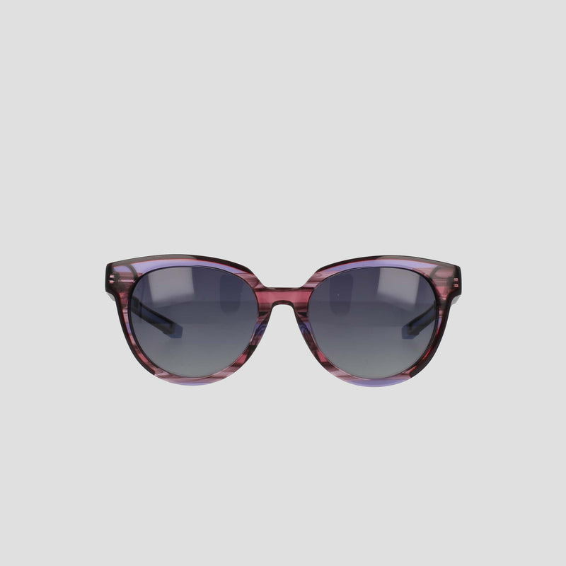 The Champion Women's Polarized Retainer Round sunglasses feature purple translucent round frames and dark tinted lenses, making a bold statement in women’s fashion eyewear, showcased on a plain light gray background.