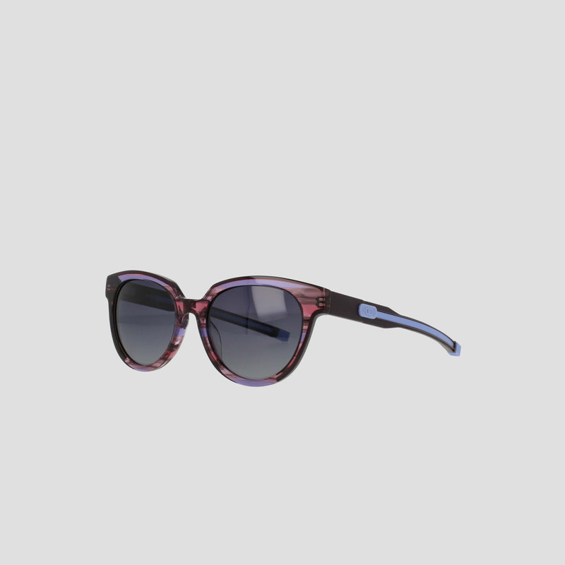 The Champion Women's Polarized Retainer Round features round dark lenses and a translucent purple and black frame, showcased on a light grey background.