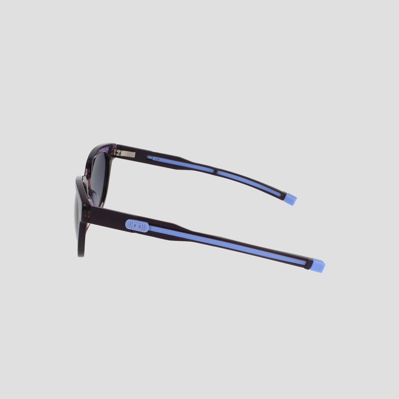 Side view of Champion Women's Polarized Retainer Round sunglasses, featuring dark purple cateye frames with light blue arm accents, set against a light gray background—ideal for women's fashion eyewear.