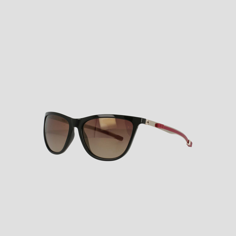 Champion's Women's Polarized Retainer Rectangle sunglasses feature a sleek black cat-eye design with dark gradient polarized lenses and striking red temples, showcased against a plain light gray background—a bold statement in athleisure eyewear.