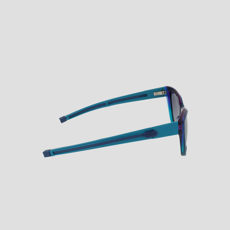 Side view of Champion Women's Polarized Retainer Square sunglasses, featuring blue translucent handmade acetate frames with rectangular lenses and thick arms, displayed on a plain light gray background.