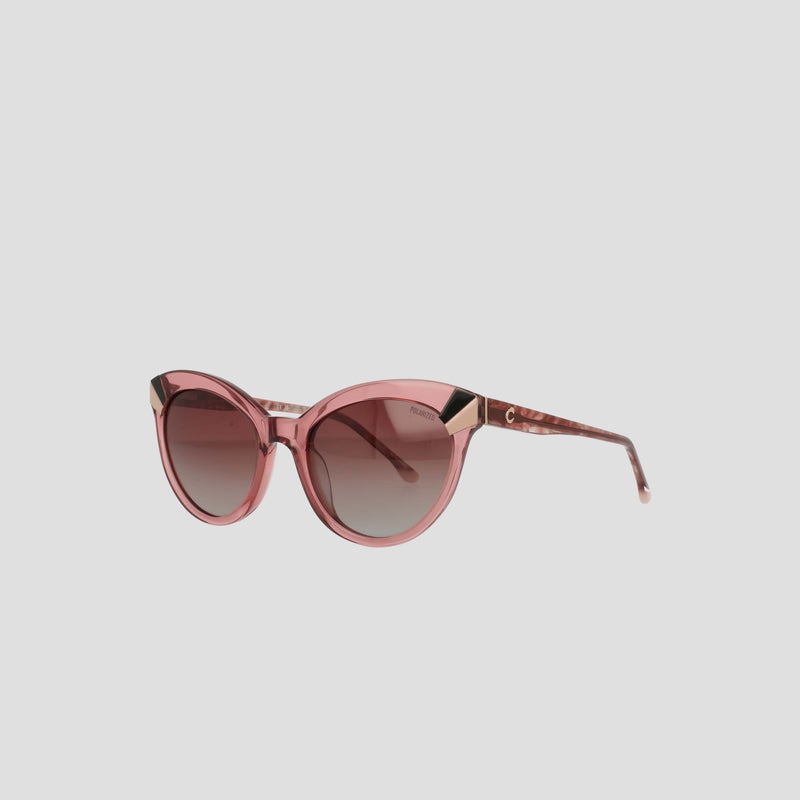 Champion Women's Polarized Cateye sunglasses featuring a pink cat-eye frame, dark gradient polarized lenses, gold accents at the corners, and patterned arms, shown against a plain white background.