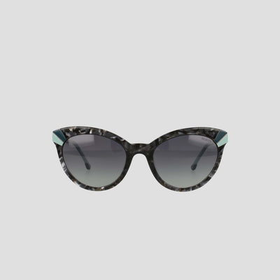 Champion’s Women's Polarized Cateye sunglasses feature black and gray marbled frames, dark gradient lenses, and distinctive teal accents at the upper outer corners. Displayed against a simple light background, these chic cat-eye sunglasses not only offer practical sun protection with their polarized gradient lenses but also elevate your style.